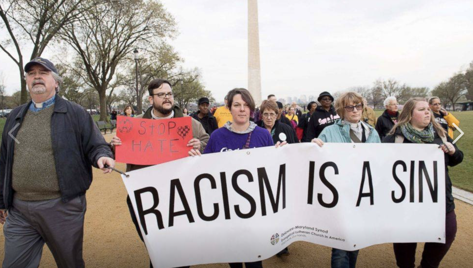 Synod leaders marching in Washington D.C. with a banner that reads 'Racism is a sin.'