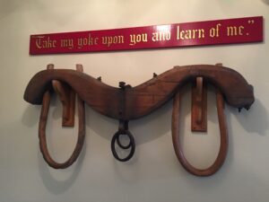 A yoke with the words "Take my yoke upon you and learn of me" written above it.