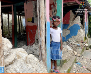 A child standing in rubble in Haiti